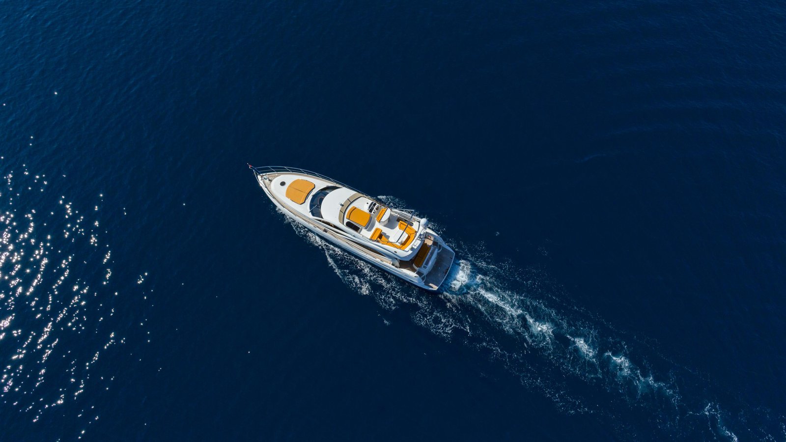 Aerial view of yacht cruising through deep navy waters